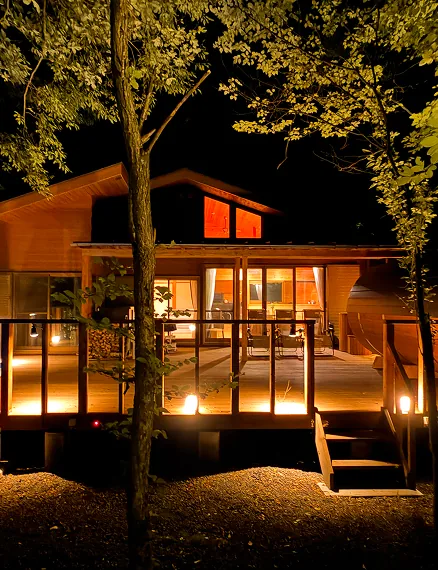 Exterior of the forest villa glowing in the night light (Noël Kitakaruizawa Forest)