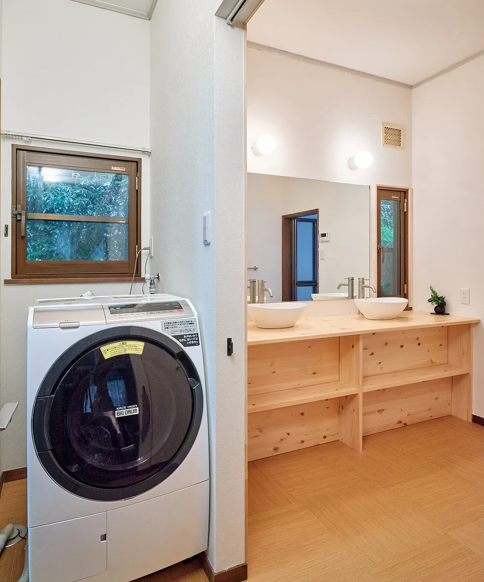 Separate vanity with twin basins, next to the drum-type washer-dryer