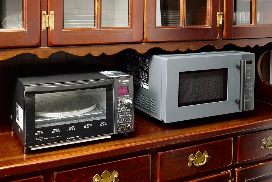 Toaster oven and microwave on the wooden sideboard