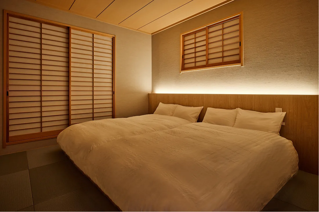 Japanese-style bedroom wrapped in soft light through shoji screens