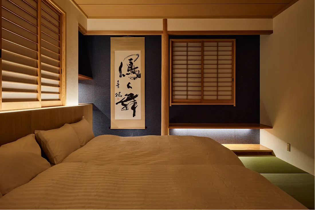Tatami bedroom with indigo walls and a calligraphy scroll