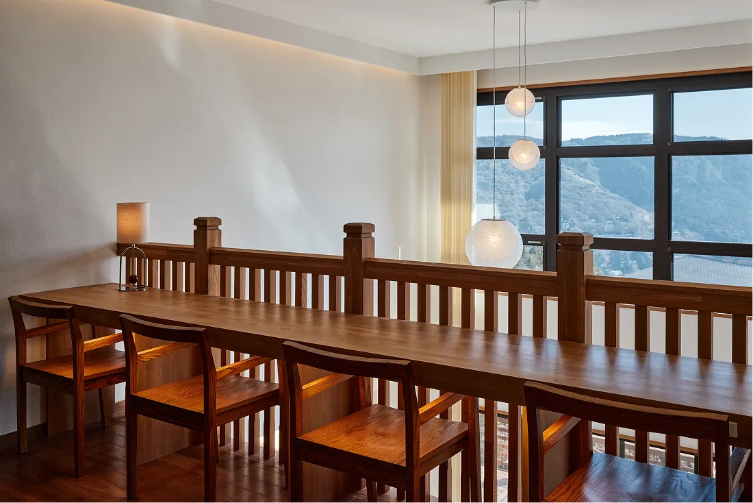 Long counter table and chairs facing the windows toward Lake Ashi