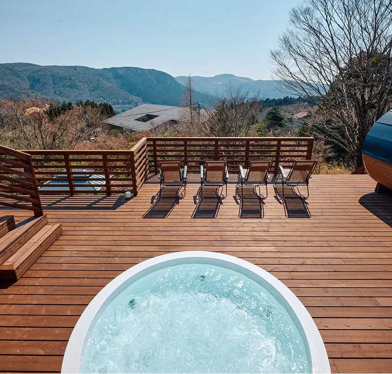 Large jacuzzi and loungers on the wooden deck with mountain views