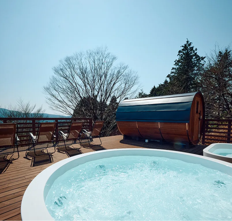 Jacuzzi and barrel sauna under a clear blue sky