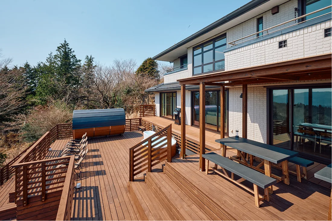 Barrel sauna and bench tables on the spacious wooden deck