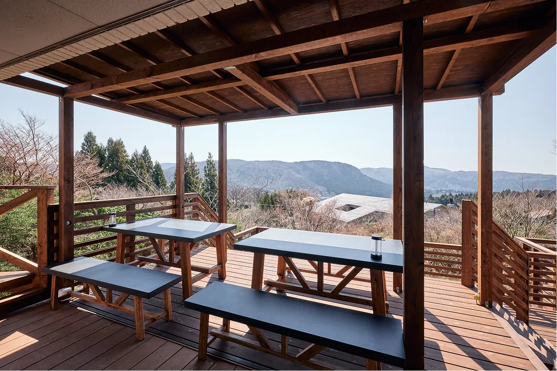 Bench tables under the pergola with views of the Hakone mountains