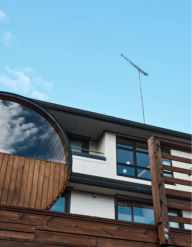 Looking up at the villa and blue sky over the barrel sauna