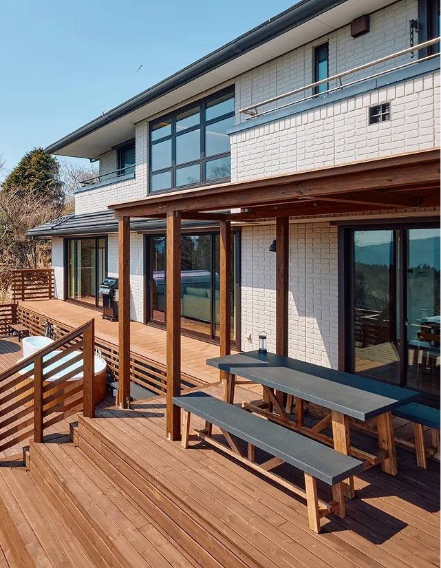 White brick exterior and pergola-covered wooden deck