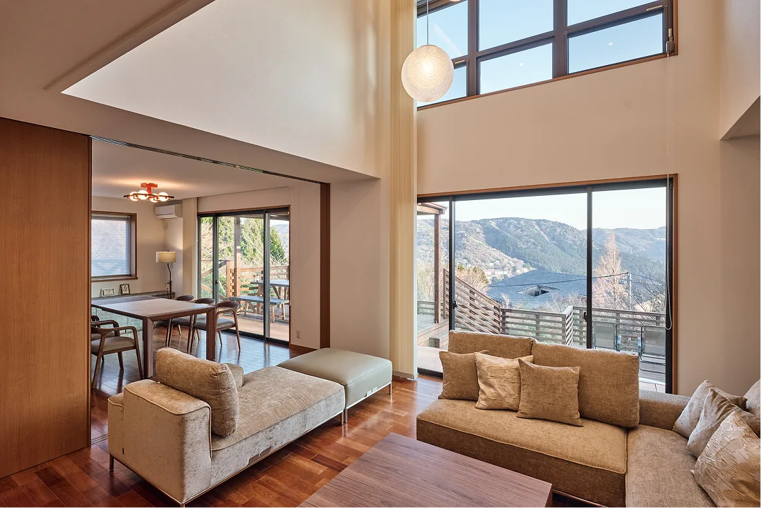Living and dining area filled with light from the skylight and tall windows